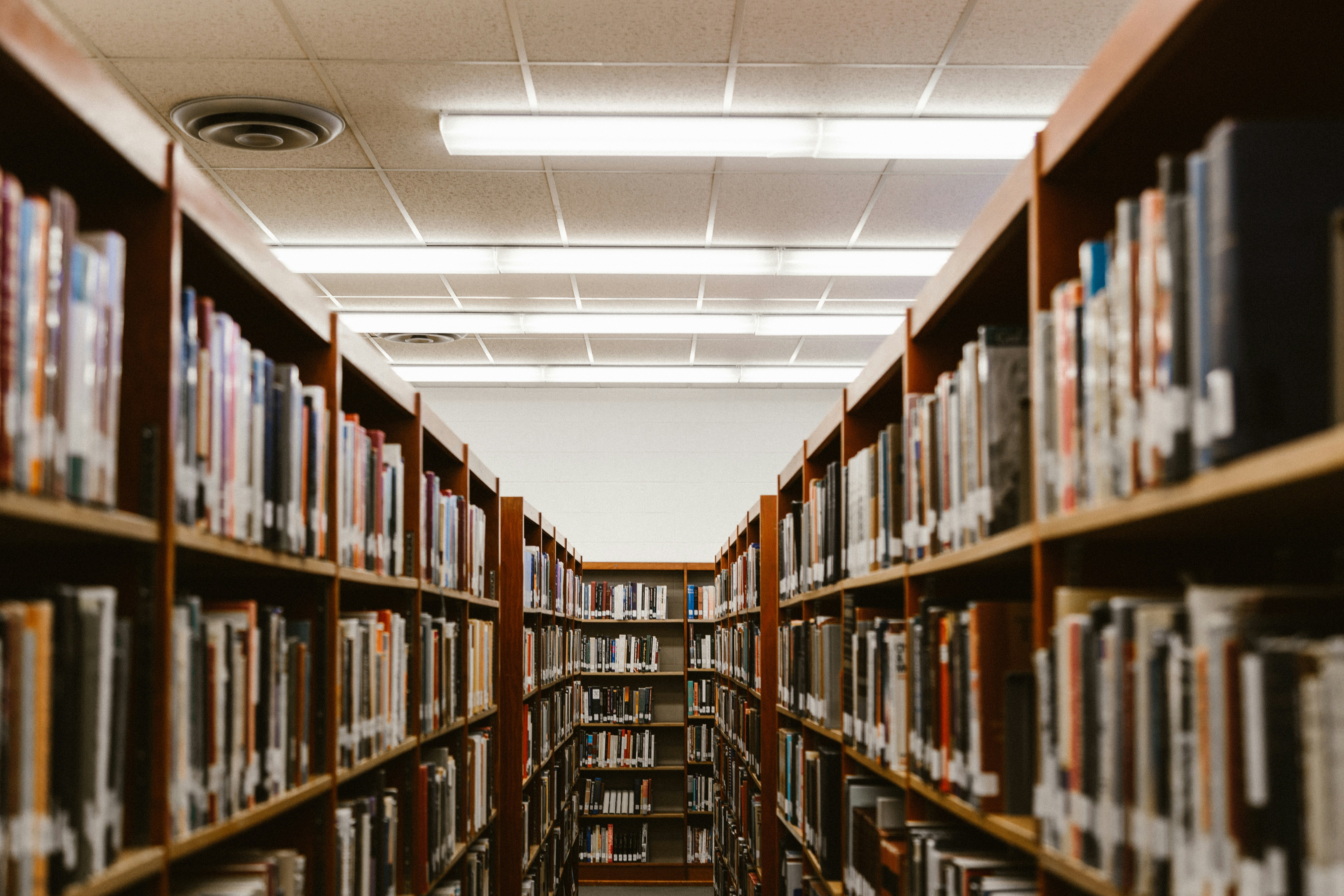An aisle with shelves of books in a library 